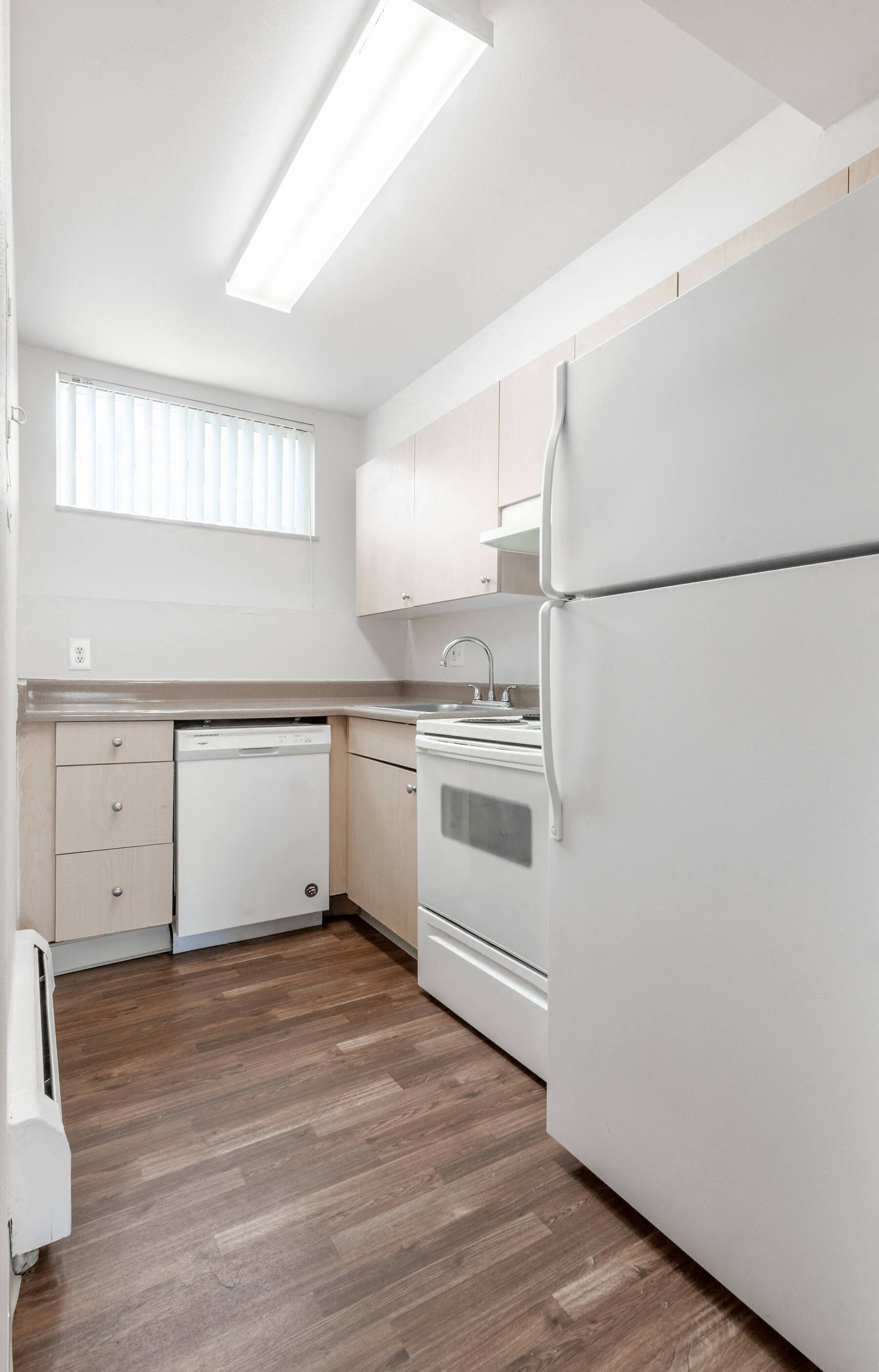 A bright, white kitchen at The Pines Apartments in Denver, Colorado.